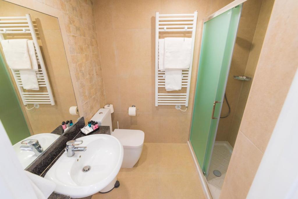 a bathroom with a sink and a toilet and a shower at Chrielka Hotel in Limassol