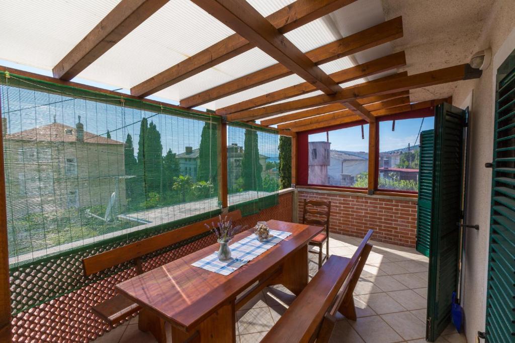 a balcony with a table and chairs and windows at JELICIC C in Crikvenica