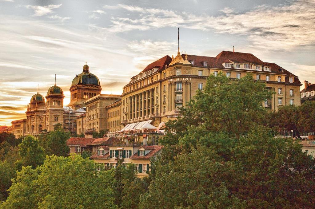 un grand bâtiment avec des arbres devant lui dans l'établissement Hotel Bellevue Palace Bern, à Berne