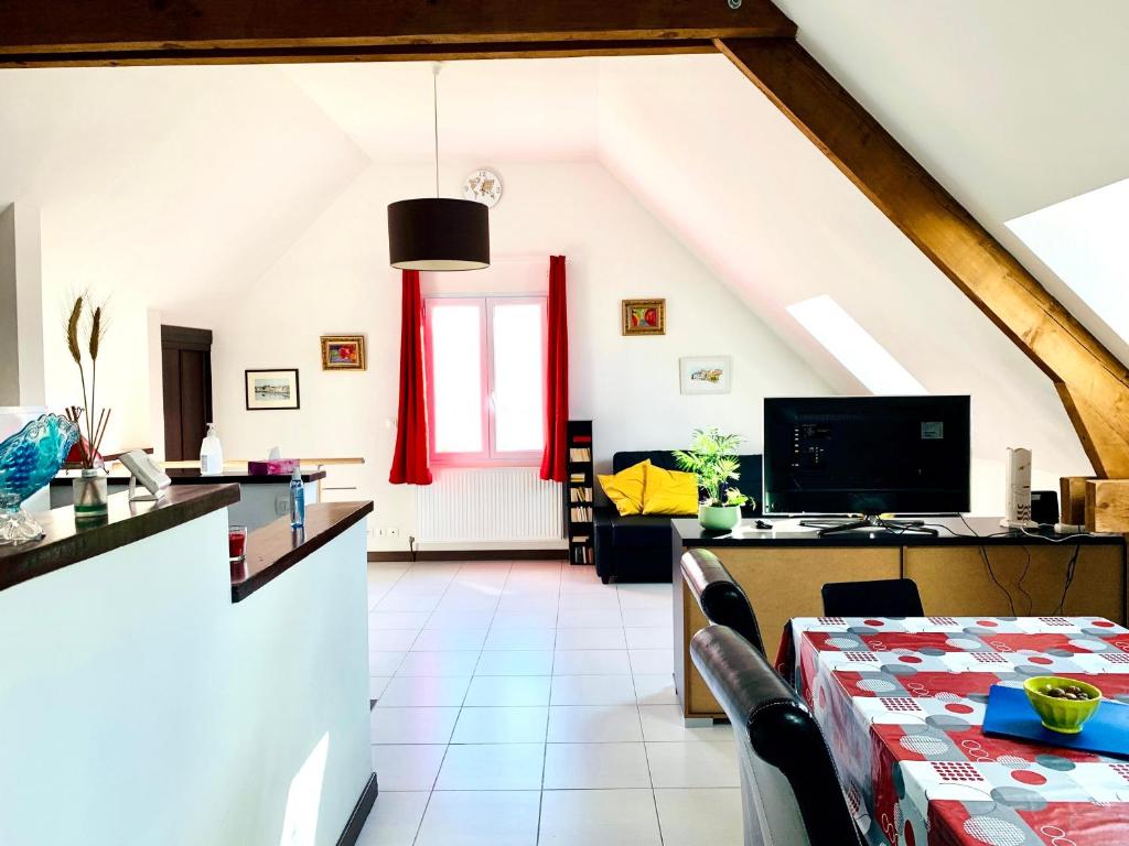 een woonkamer met een tafel en een televisie bij Le Paraty - Maison indépendante 72 m2 in Pont-Sainte-Maxence