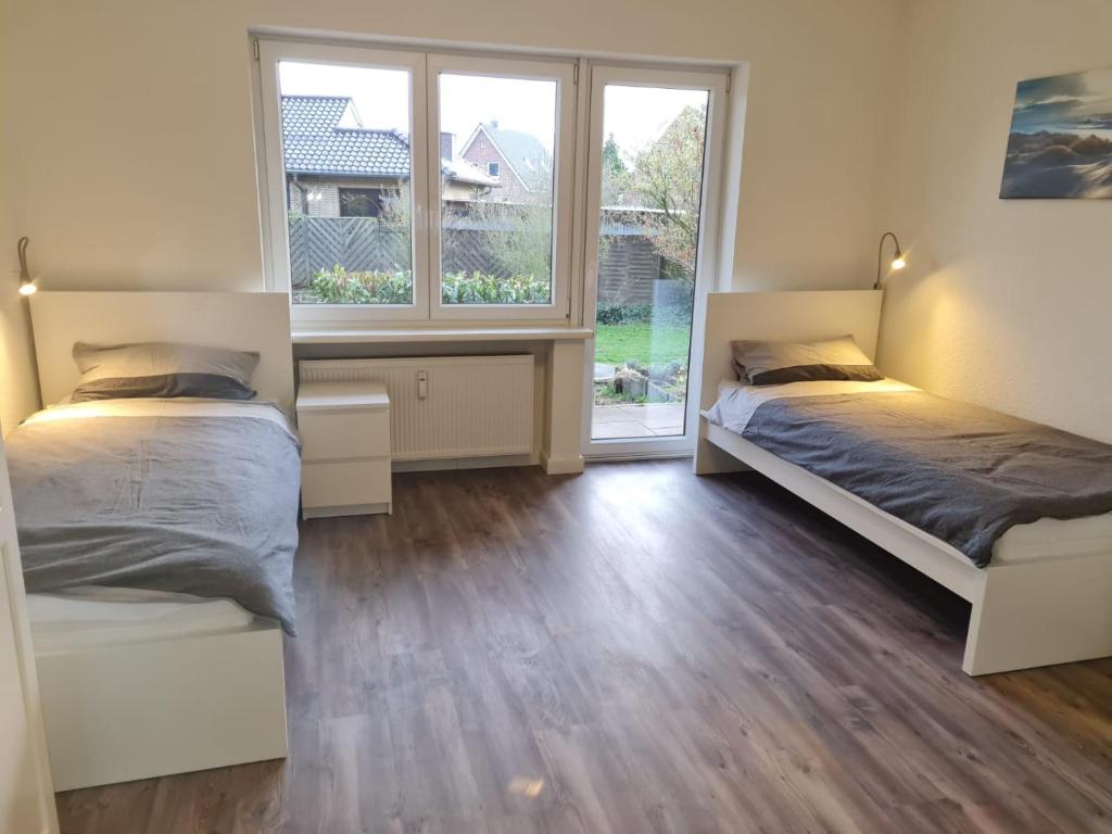 two beds in a room with two windows at Wohnen im Grünen 2 in Heiligenstedten