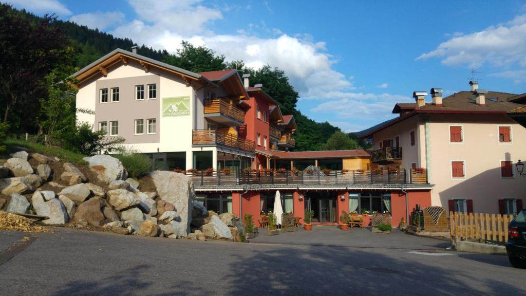 un groupe de bâtiments du côté d'une montagne dans l'établissement Alpen Garten Hotel Margherita, à Rumo