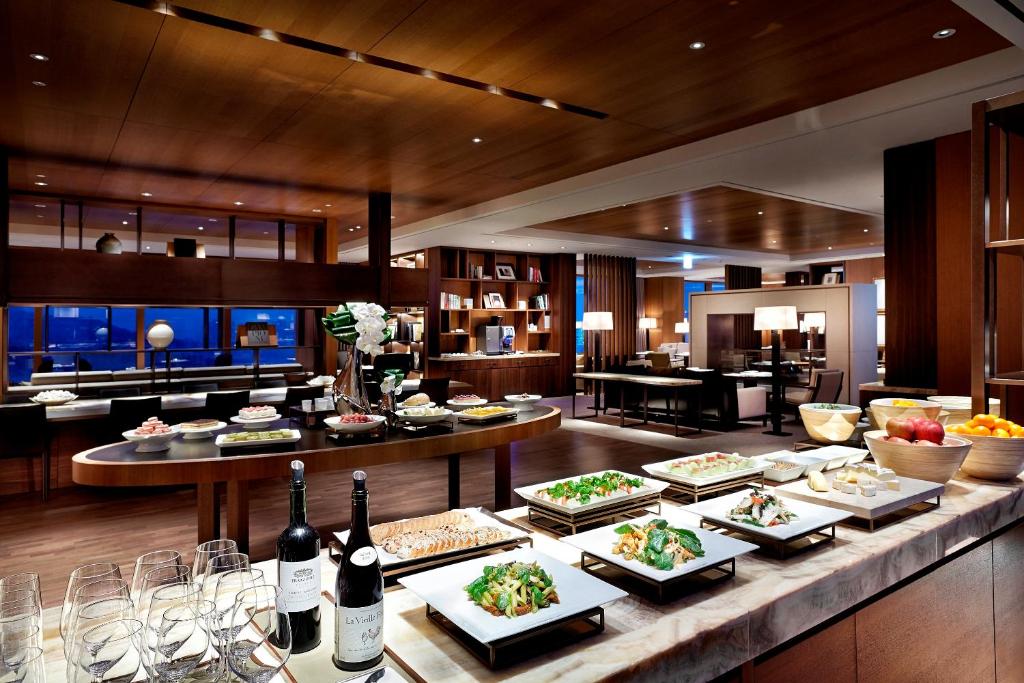 a buffet with plates of food and bottles of wine at The Shilla Seoul in Seoul