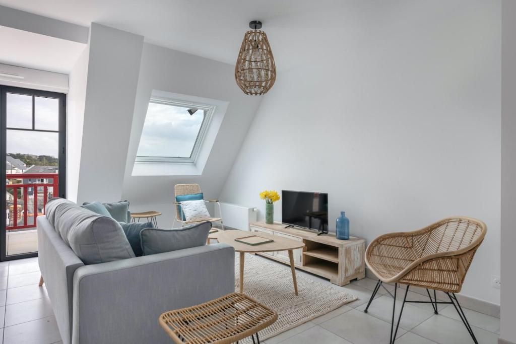 un salon avec un canapé et une table dans l'établissement Appartement pour 6 à 50m de la plage, à Pléneuf-Val-André