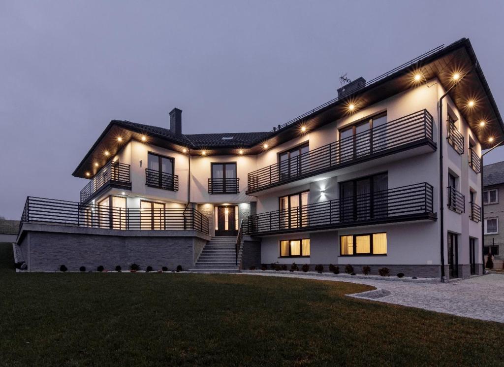 a large white house with lights on it at Apartamenty u Słodyczki in Mizerna