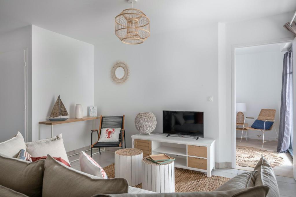 un salon avec un canapé et une télévision dans l'établissement Appartement en bord de mer à Pléneuf-Val-André, à Pléneuf-Val-André