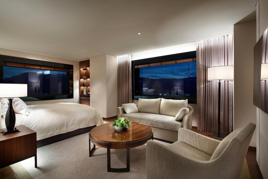 a bedroom with a bed and a couch and a table at The Shilla Seoul in Seoul
