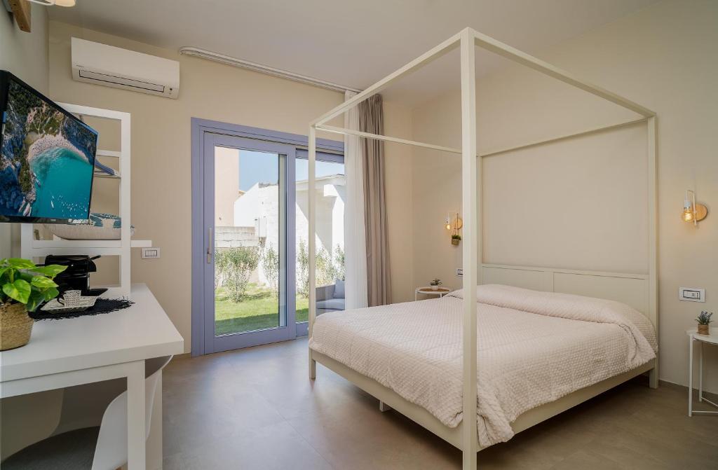 um quarto com uma cama de dossel branca e uma secretária em Enjoy Your Stay - Guest House - Olbia em Olbia