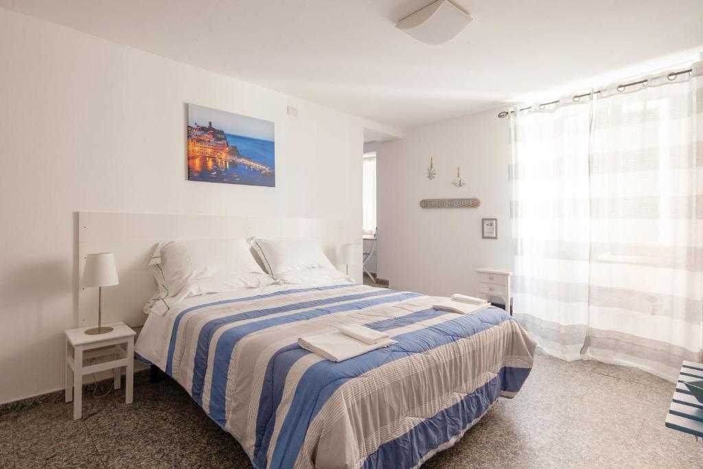a white bedroom with a bed and a window at Ludovica Flat in Vernazza