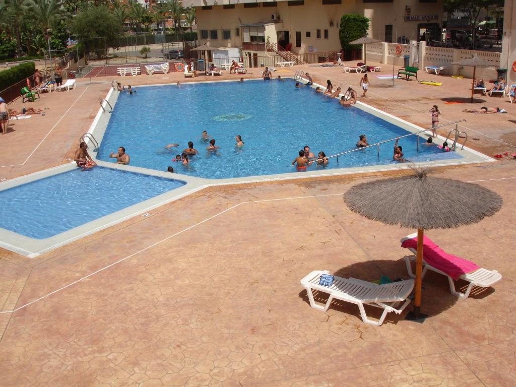 a group of people in a swimming pool with an umbrella at Acuarium 1 - Zand Properties in Benidorm