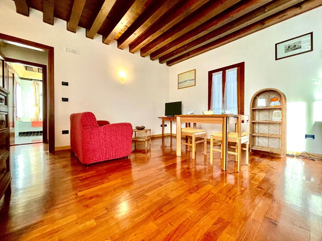 salon z czerwonym krzesłem i stołem w obiekcie Alla Barchessa di Villa Querini w mieście Preganziol