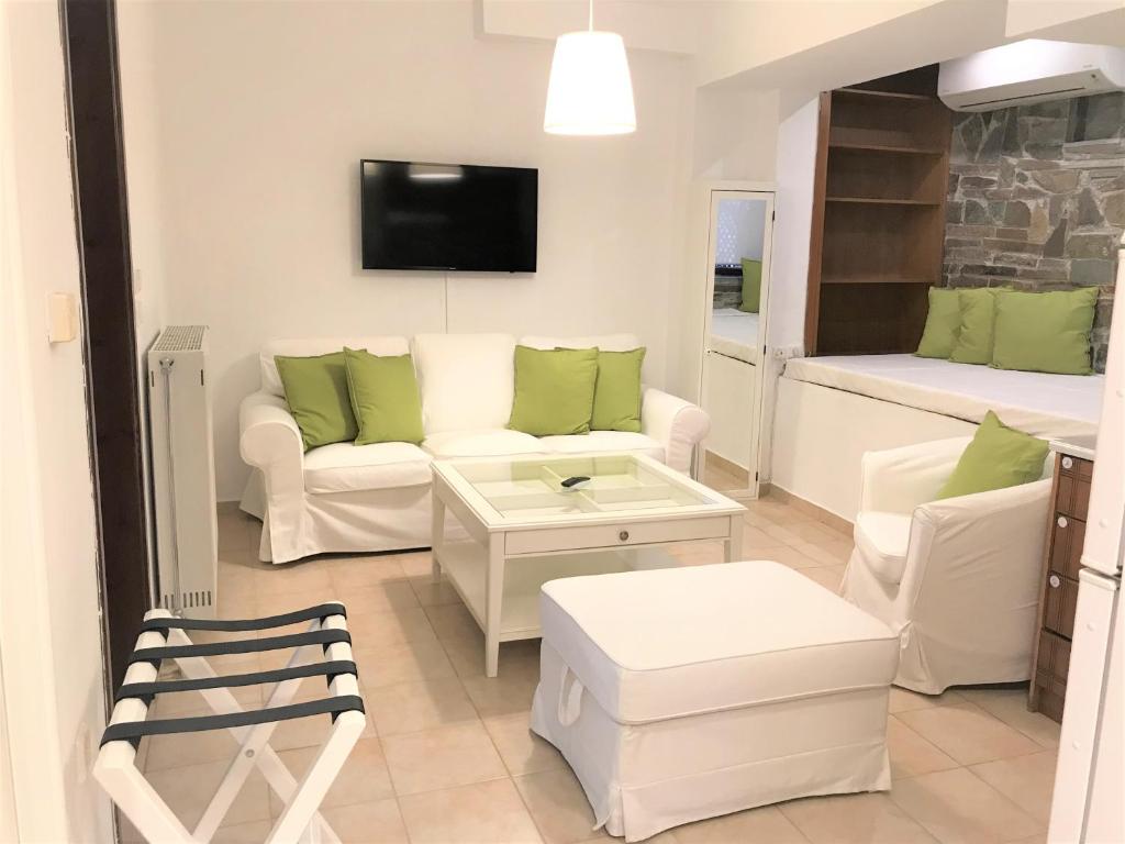 a living room with a white couch and a table at Amaryllis House in Platamonas