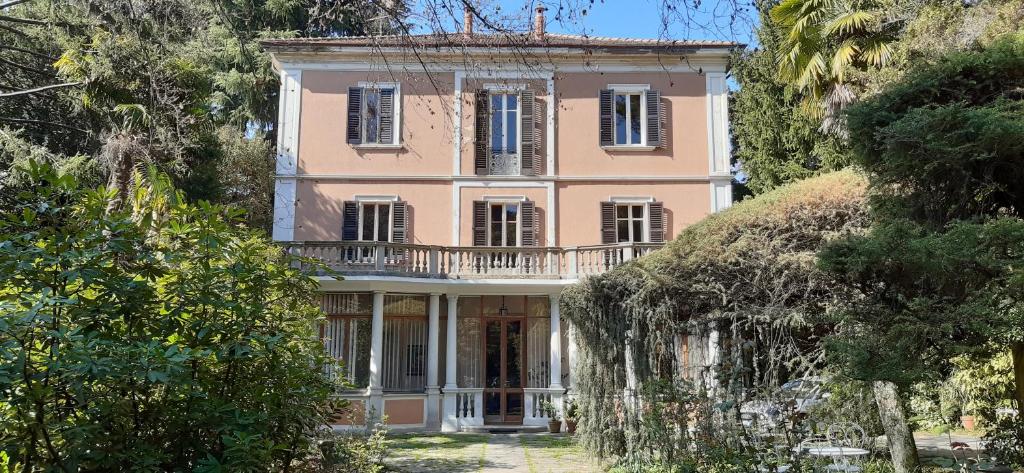 een roze huis met een balkon erop bij B&B Villa Margherita in Lesa