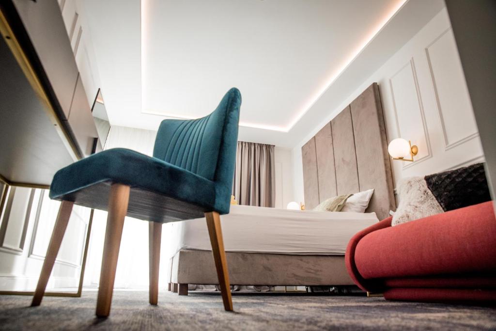 een slaapkamer met een bed en een stoel in een kamer bij Hotel Krilo in Podstrana