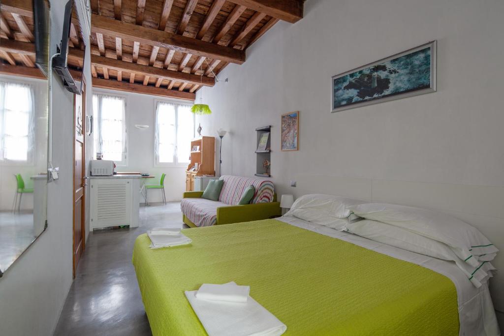 a bedroom with a green bed and a living room at Ludovica Studio - Backpackers House Vernazza in Vernazza