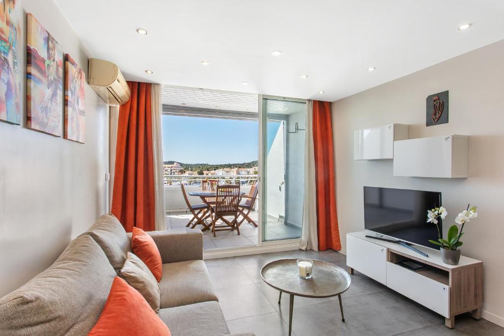 un salon avec un canapé et une télévision dans l'établissement Le Nude - Port Ambonne Village Naturiste, au Cap d'Agde