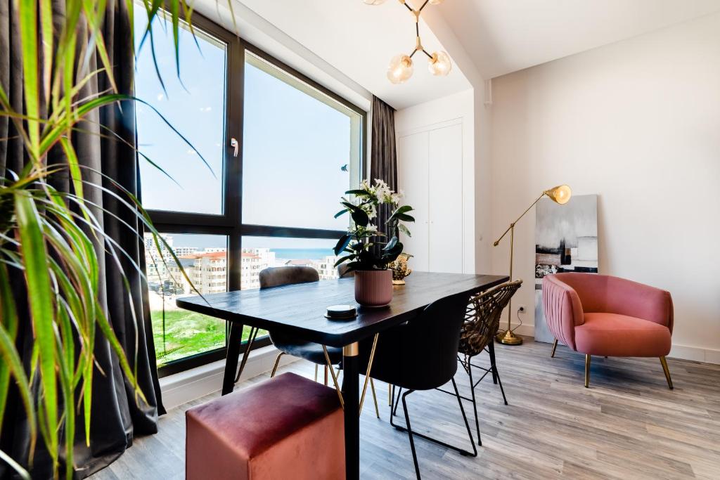 a dining room with a table and chairs and a large window at Onix 75 in Mamaia Sat/Năvodari