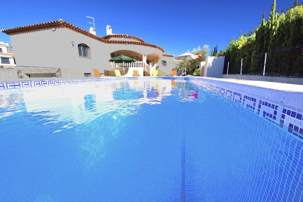 a large blue swimming pool in front of a house at Villa Nicole in L'Ampolla