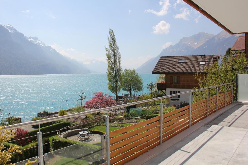 a house with a balcony with a view of the water at Holiday Apartment Alpenblick in Brienz