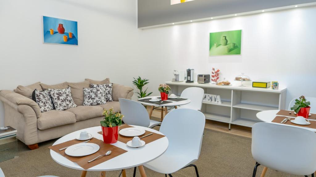 salon z białymi stołami i białymi krzesłami w obiekcie Zeta Rooms w mieście Caserta