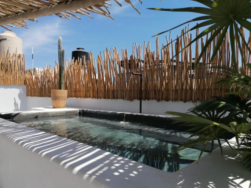 - une piscine dans un jardin avec une clôture en bois dans l'établissement Petit Hotel Hafa, à Sayulita