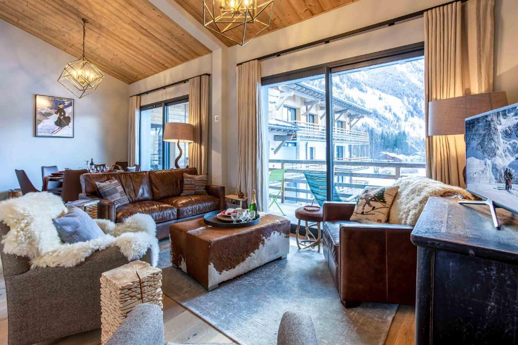 uma sala de estar com mobiliário de couro e uma grande janela em La Cordee 124 Apartment - Chamonix All Year em Chamonix-Mont-Blanc