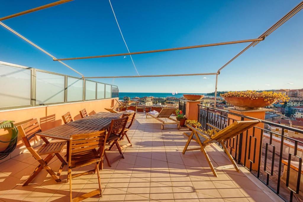 een balkon met tafels en stoelen en uitzicht op de stad bij CasaViva - Trilocale a Varazze con terrazza vista mare in Varazze