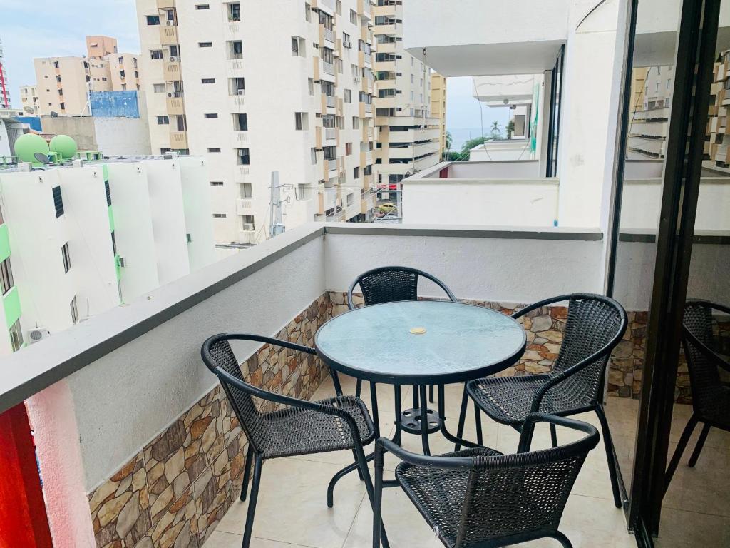 una mesa y sillas en el balcón de un edificio en Santa Marta Apartamentos Salazar - Caribe, en Santa Marta
