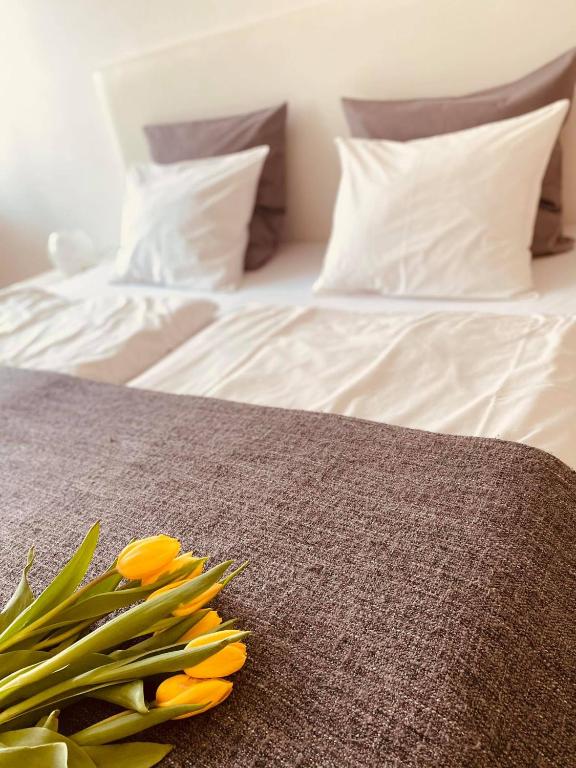 a bed with a bunch of yellow flowers on it at Trio Apartments in Ostrava