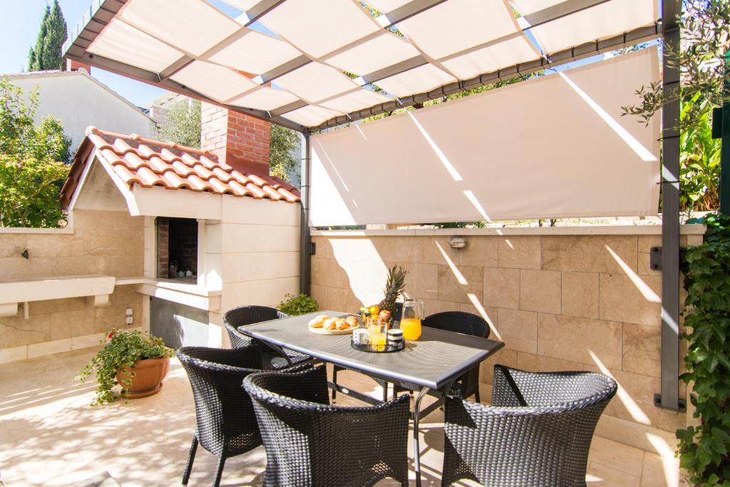 un patio al aire libre con mesa y sillas en Apartments Rici, en Bol