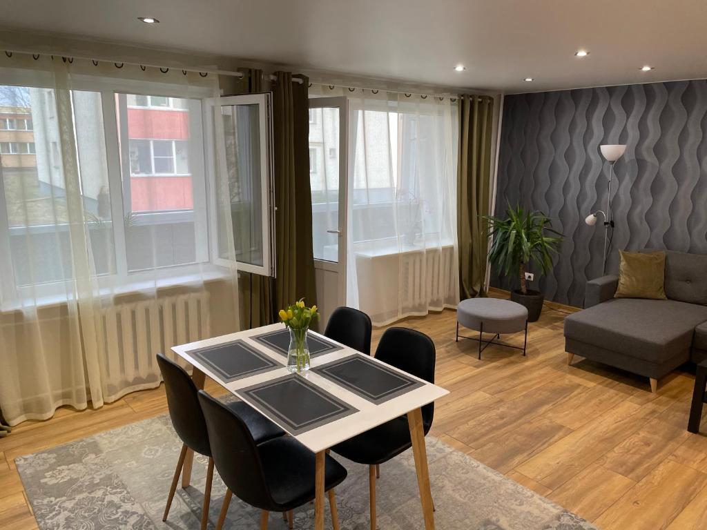 a living room with a table and chairs and a couch at IGNALINOS APARTAMENTAI in Ignalina