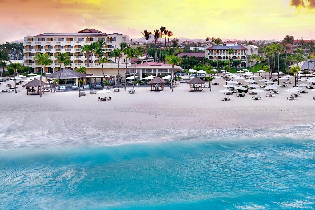 - une vue aérienne sur une plage dotée de chaises et de parasols dans l'établissement Bucuti & Tara Boutique Beach Resort - Adult Only, à Palm-Eagle Beach