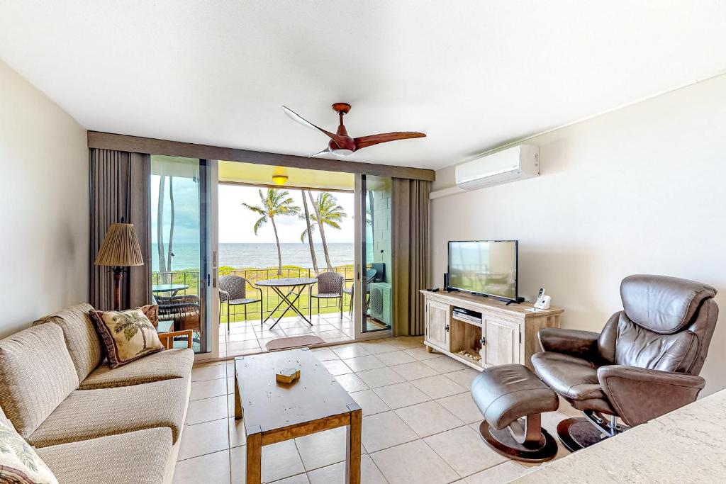 ein Wohnzimmer mit einem Sofa und einem TV in der Unterkunft Hale Kai O Kihei in Kihei