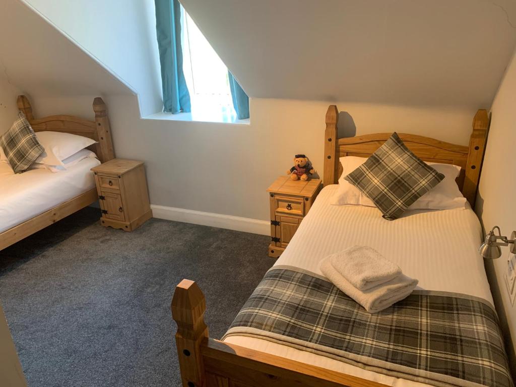 2 camas individuais num quarto com uma janela em Ardvaich House em Oban