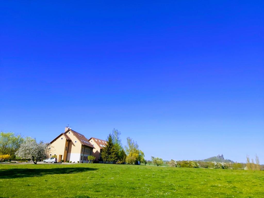 een huis op een heuvel met een groen veld bij Resort Český ráj in Troskovice