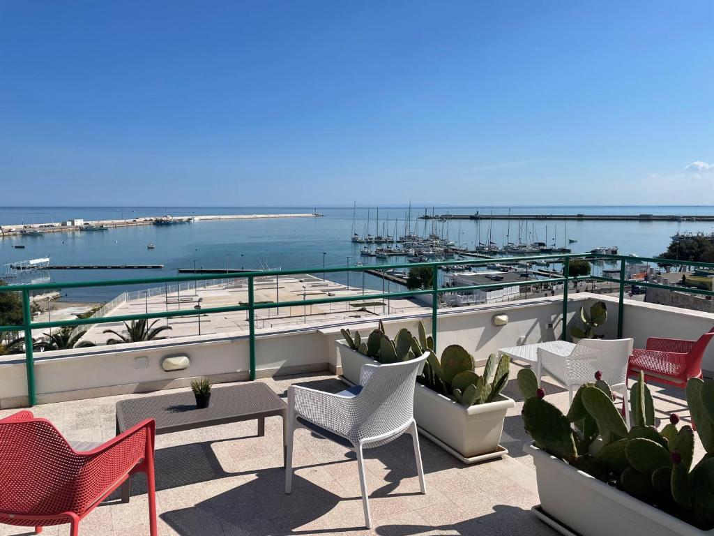 a balcony with chairs and tables and a view of the ocean at Diomede Rooms - Manfredi Homes&Villas in Manfredonia