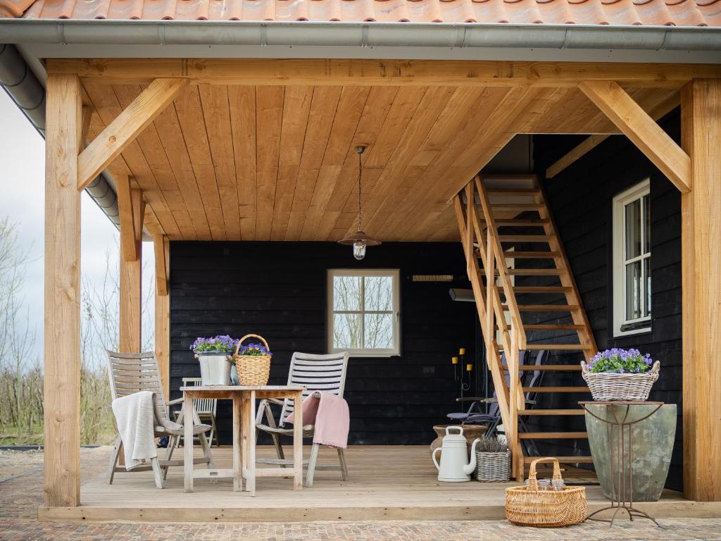 porche de madera con mesa y sillas en Landgoed het Heuvelbosch, en Waardenburg