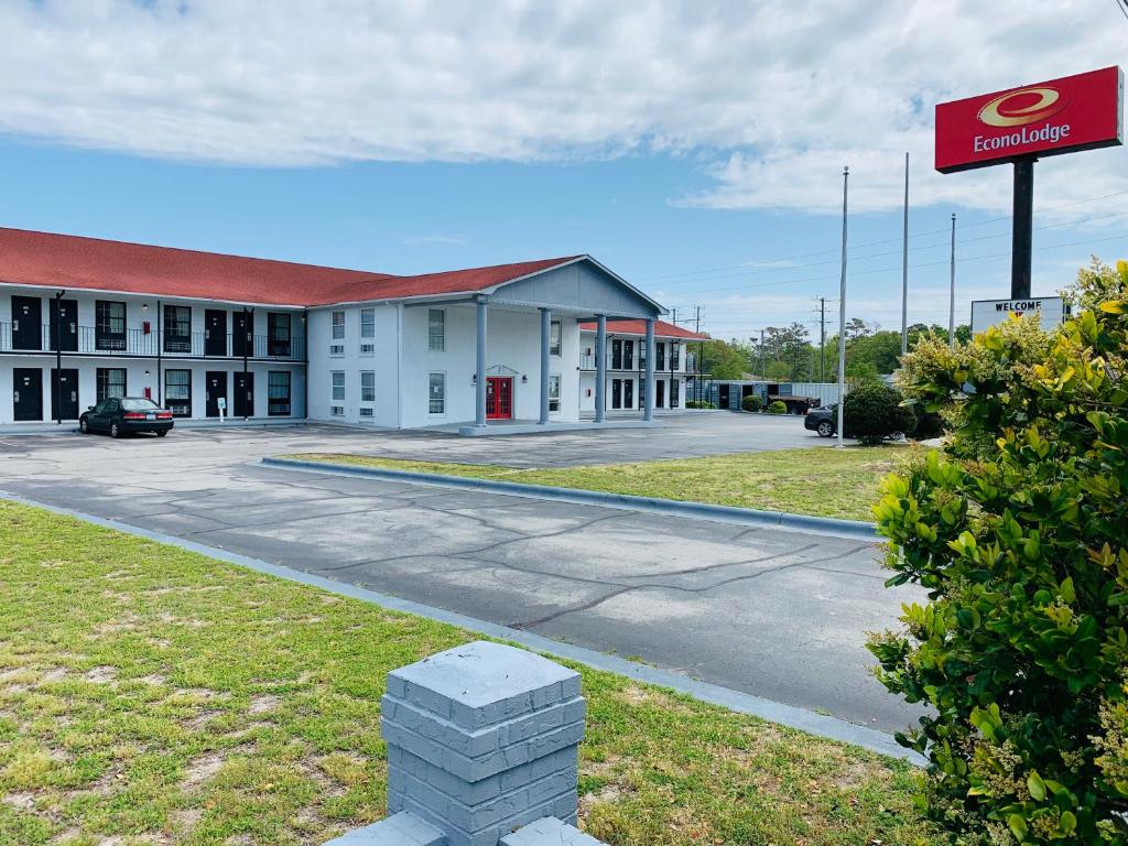 ein großes weißes Gebäude mit einem Schild davor in der Unterkunft Econo Lodge Crystal Coast in Morehead City