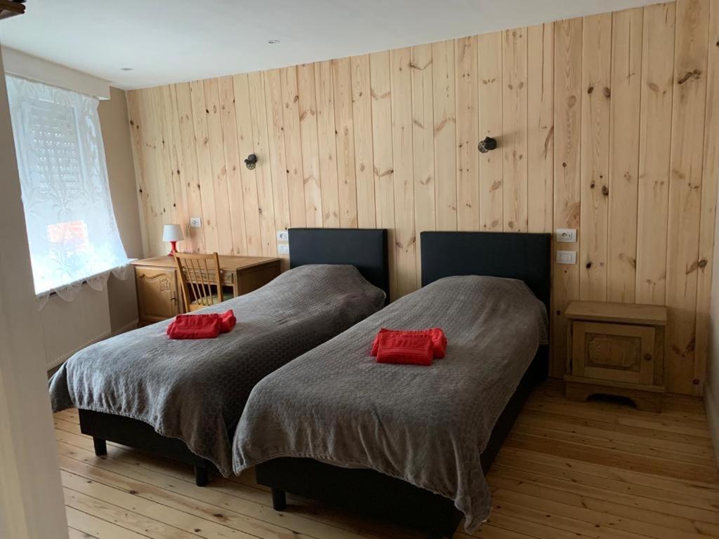 2 camas en una habitación con 2 almohadas rojas. en Huis Buizemont, en Geraardsbergen