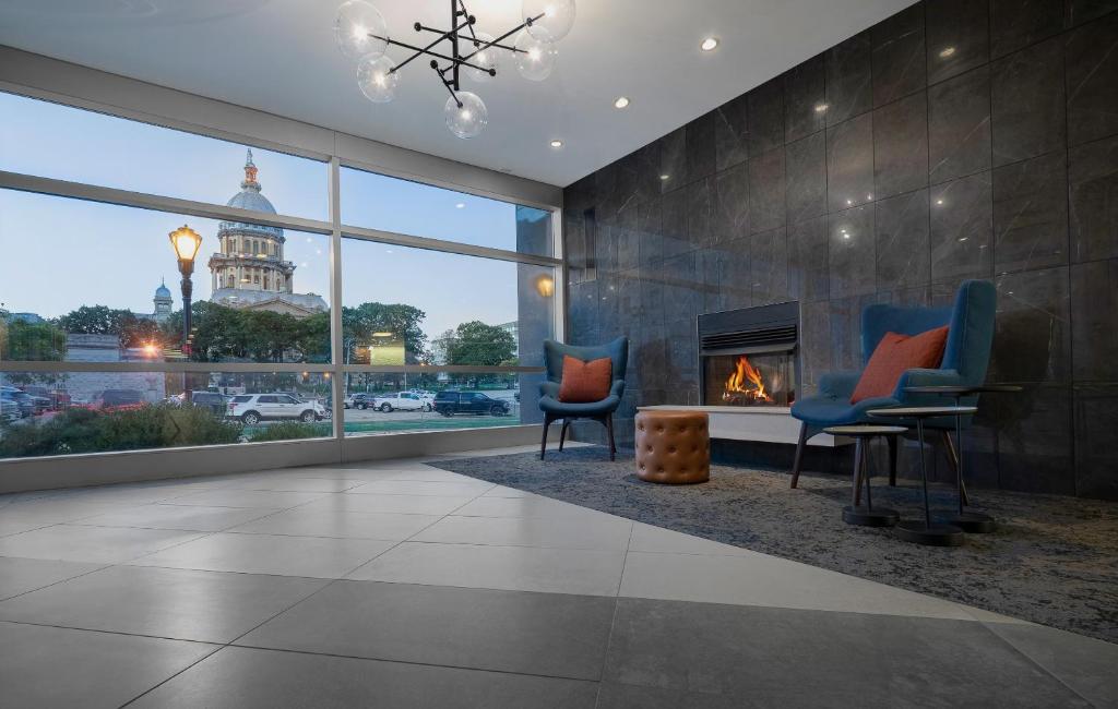 a living room with two chairs and a fireplace at State House Inn in Springfield