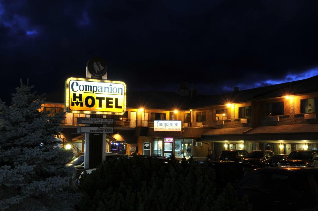 una señal de motel frente a un edificio por la noche en Companion Hotel Motel en Hearst
