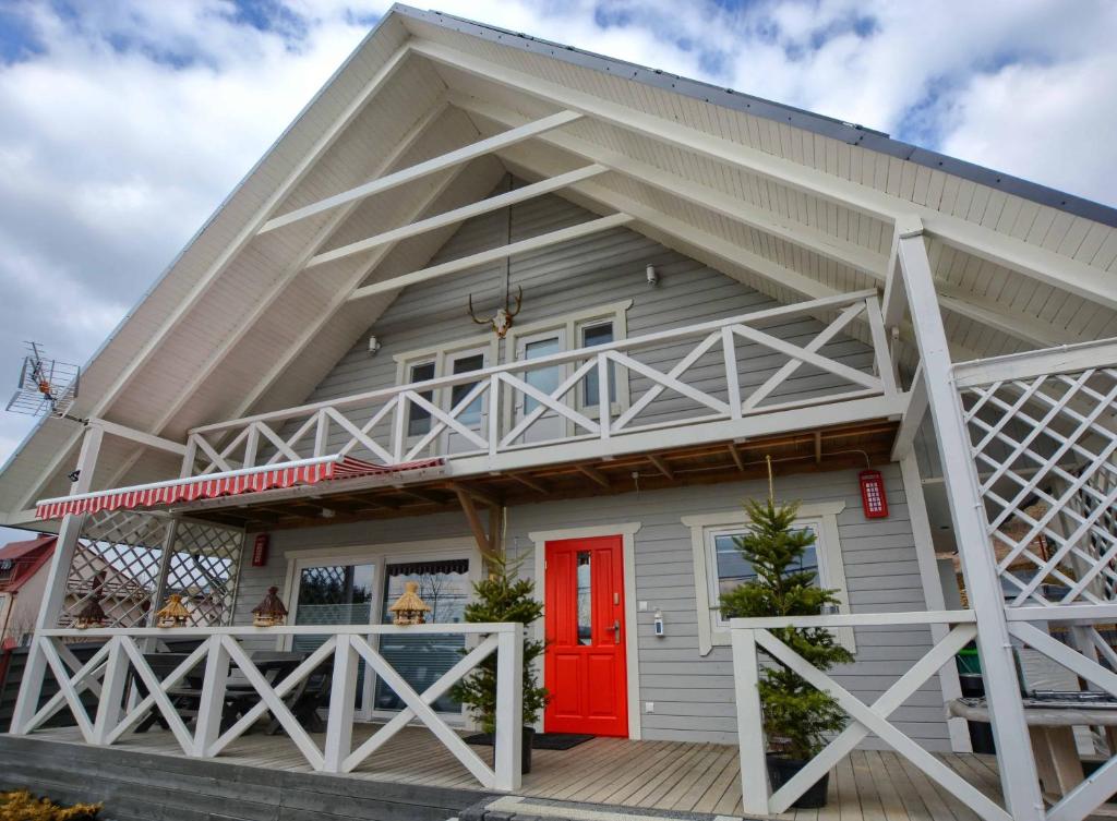 a house with a red door on a deck at Przystanek Skandynawia in Uherce Mineralne (7)