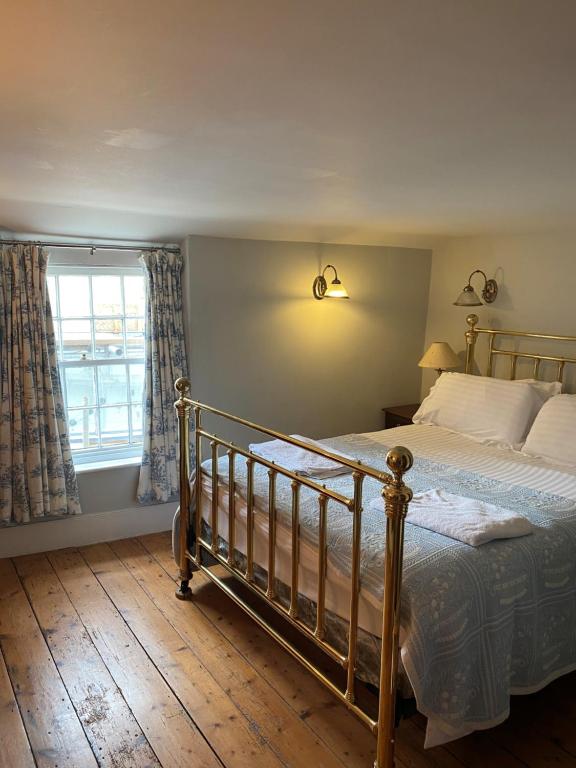 a bedroom with a bed and a window at Little Monmouth 4 bedroom cottage, Old town Lyme Regis, dog friendly and parking in Lyme Regis