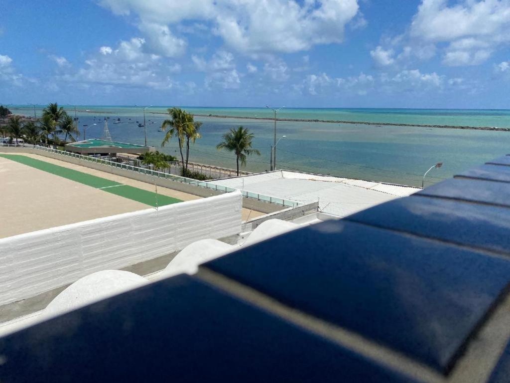 uma vista para um campo de ténis e para o oceano em Flat beira mar, Olinda 4 Rodas 313 em Olinda