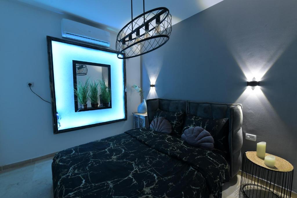 een slaapkamer met een zwart bed en een blauwe muur bij יחידת יוקרה נועם in Eilat