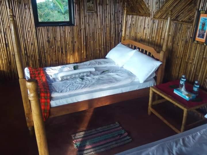 un piccolo letto in una stanza con un tavolo di Sipi Coffee Lodge a Kapchorwa