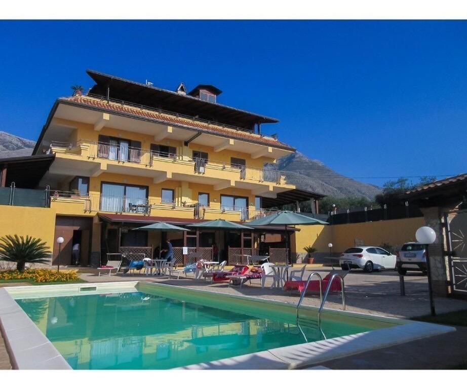 um hotel com piscina em frente a um edifício em Mare e Monti em Trivio