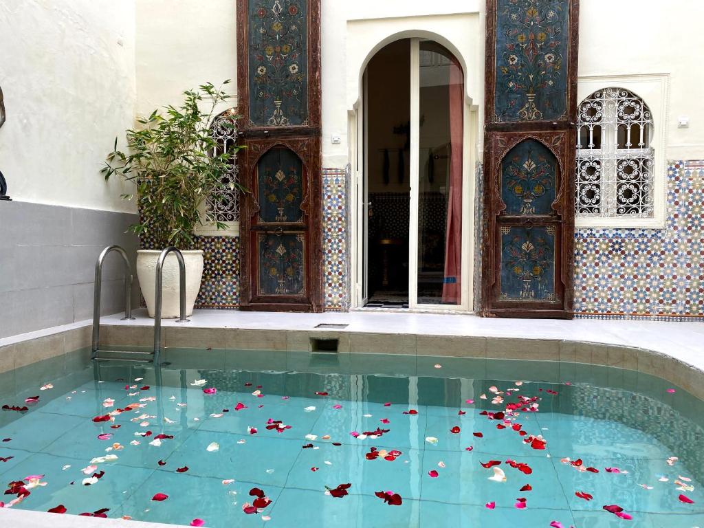 een zwembad met bloemen op de vloer bij Maison Du Tresor in Marrakesh