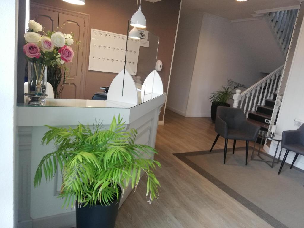 a lobby with a counter with flowers and plants at Hotel El Millón in Viveiro