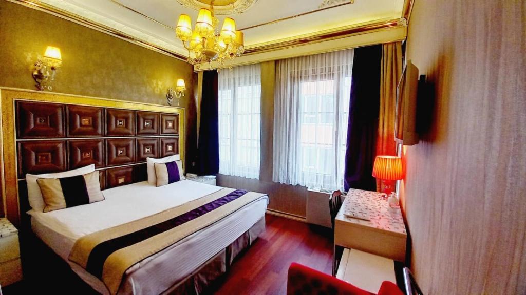 Habitación de hotel con cama y lámpara de araña. en Bakirkoy Tashan Business & Airport Hotel en Estambul